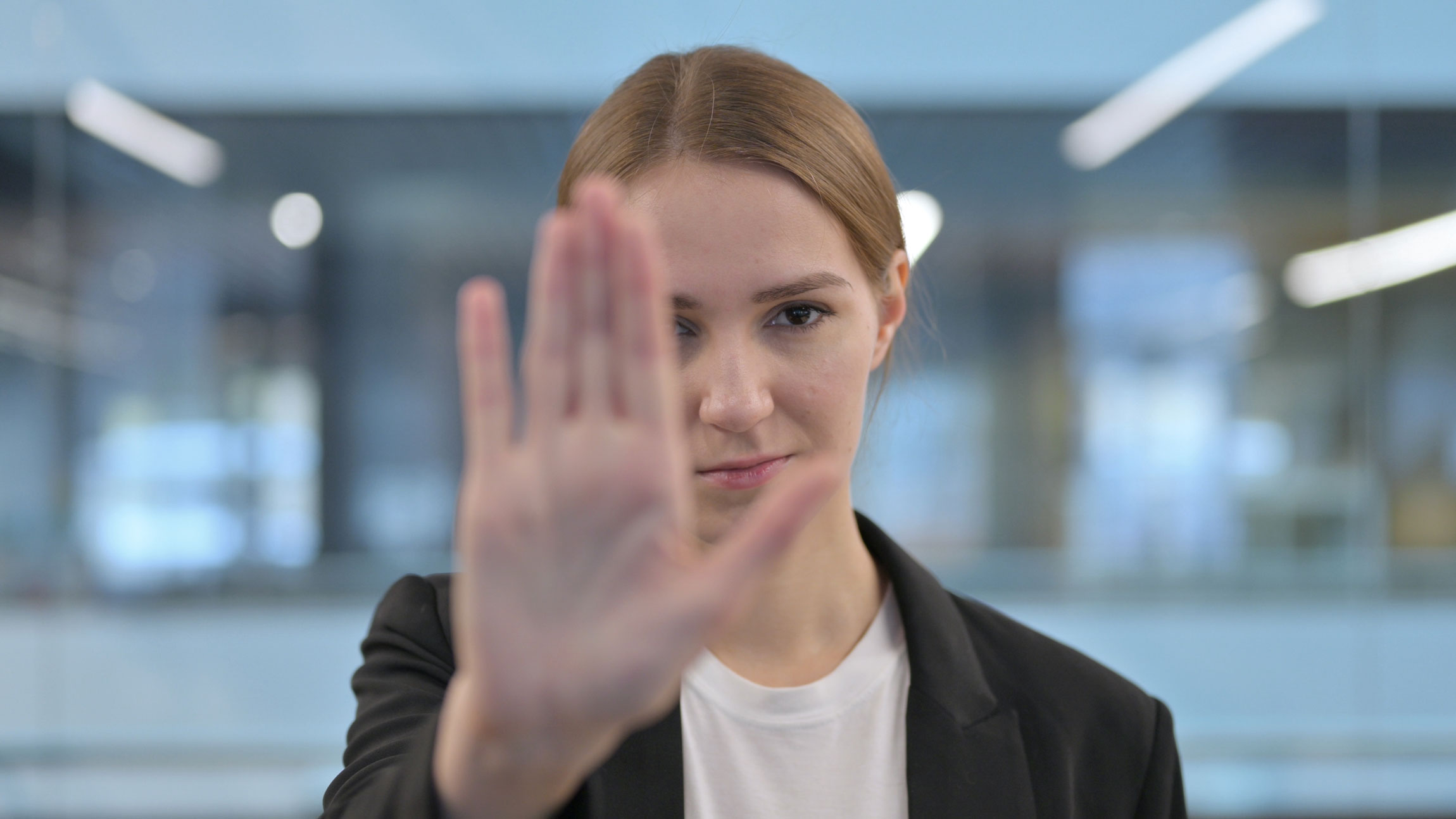 Eine junge Person macht mit der Hand ein Stopp-Zeichen